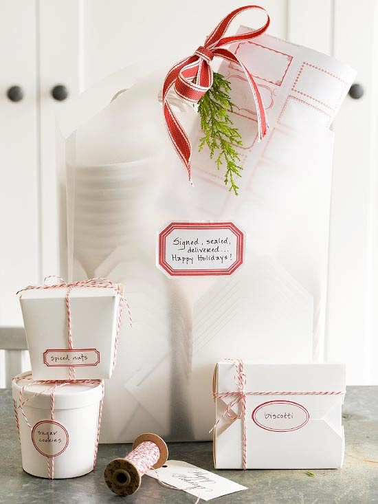 several gifts all wrapped in white paper with red ribbon.