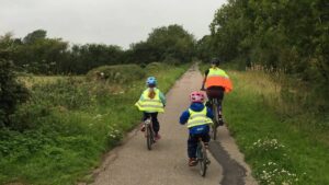 A mother and her children cycle to school on the Phoenix Trail